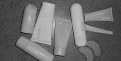 Collection of rhode skincare products on a dark surface