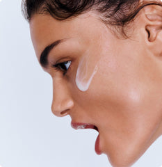 Model with a swatch of Peptide Glazing Fluid on face
